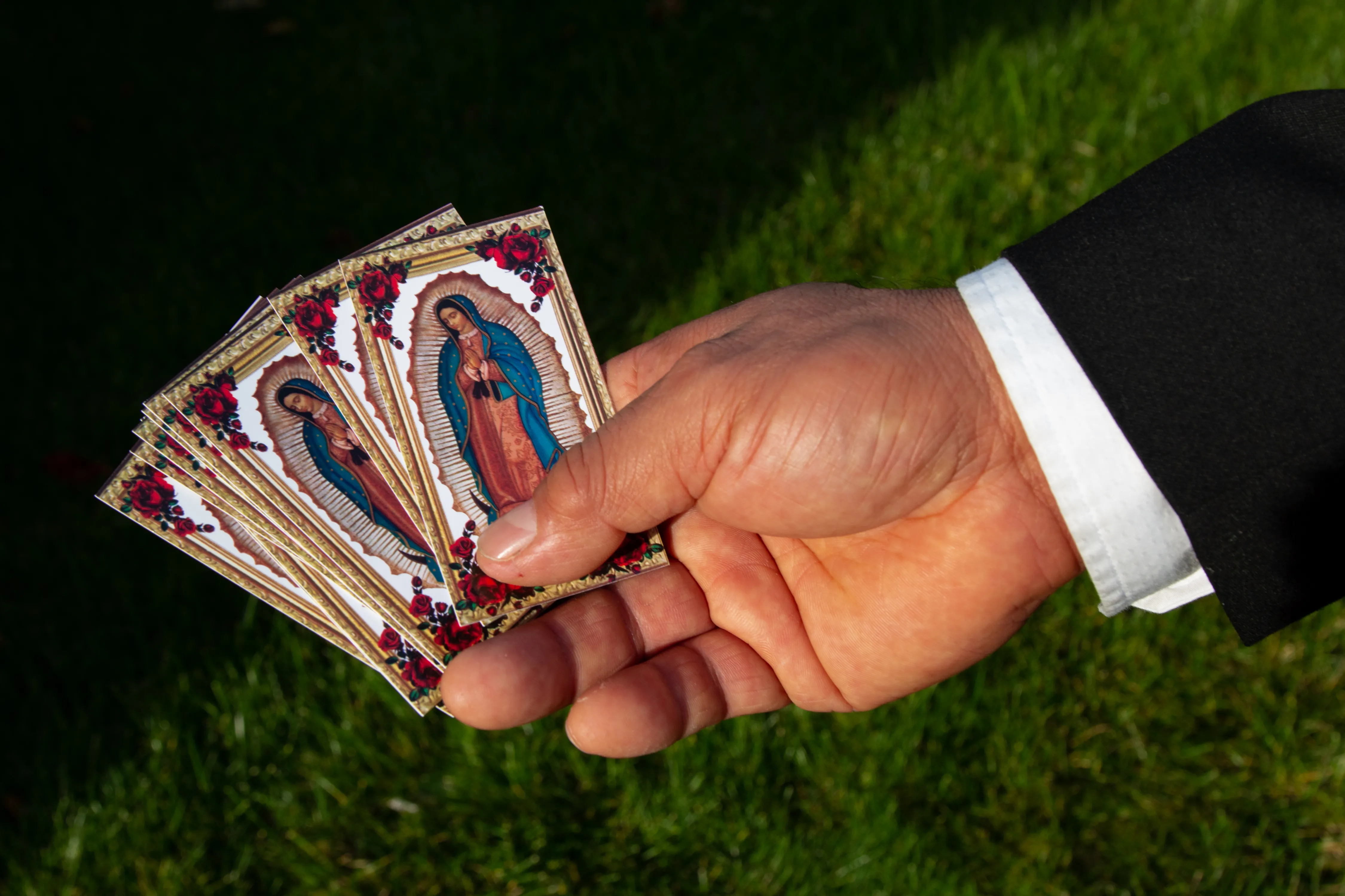 A person holding images of la guadalupe.